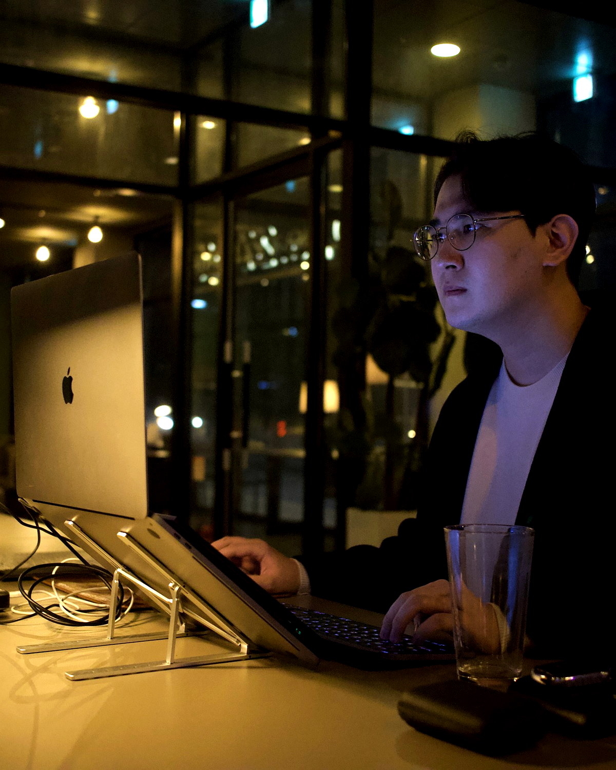 Seongsoo Shin working on a laptop in a warm evening workspace